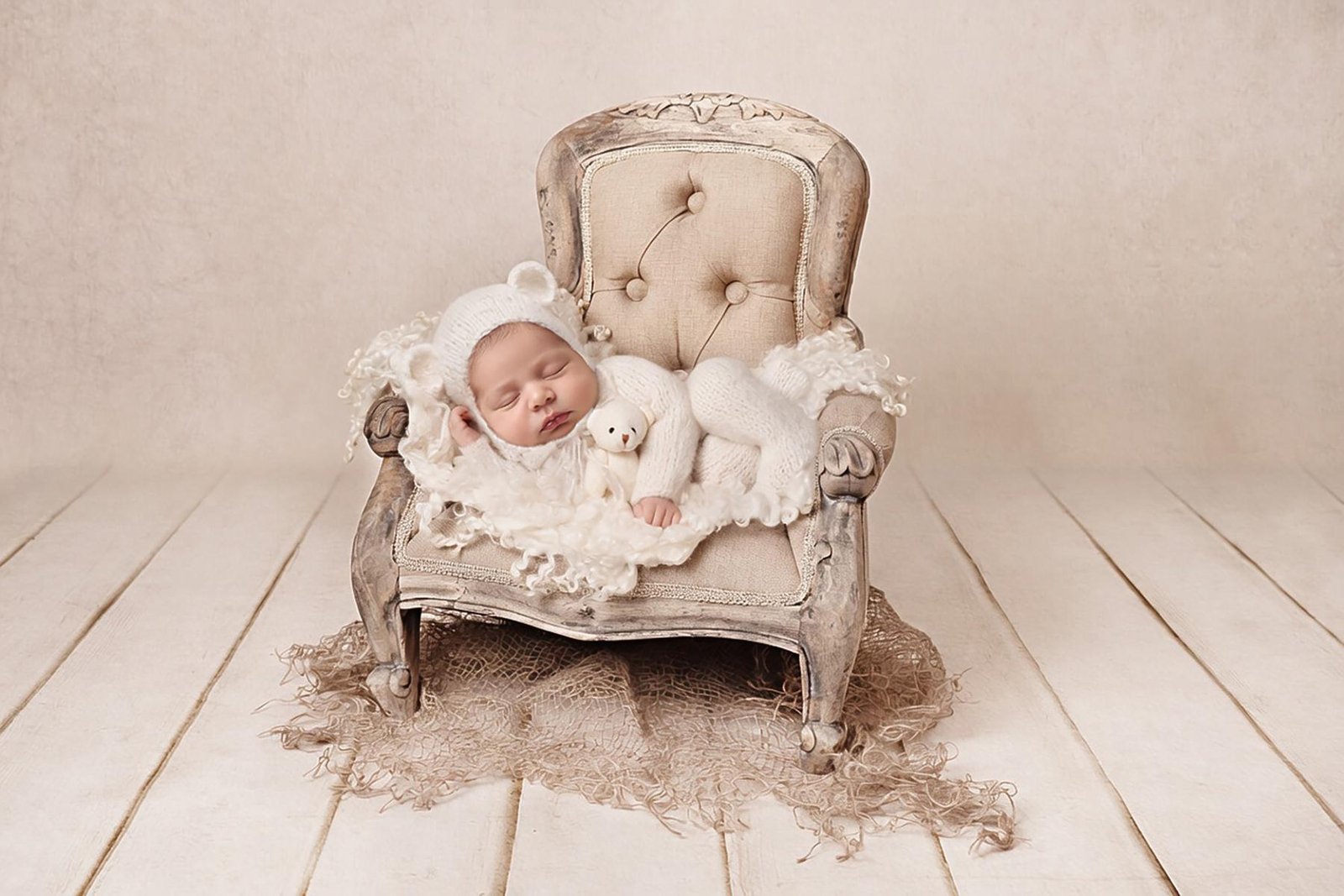 Newborn baby posed on small chair in neutral studio setting – Surrey newborn photographer
