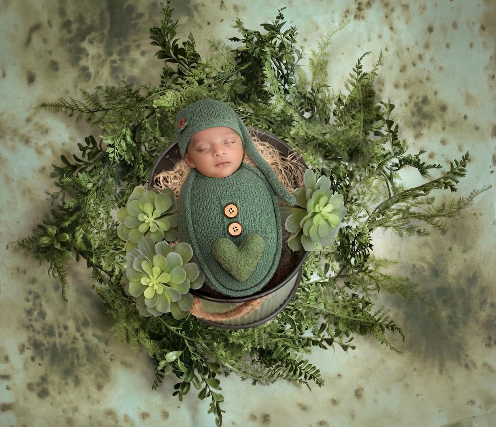 Newborn baby in green foliage nest with natural styling – Surrey newborn photographer